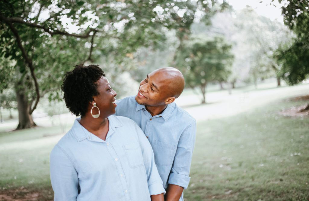 Couples Couple smiling together in blue shirts outside